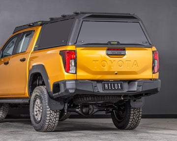 toyota hilux n90 2026 sunglow orange with ironman 4x4 raid aluminium ute canopy aluminium doors rear three quarter angle